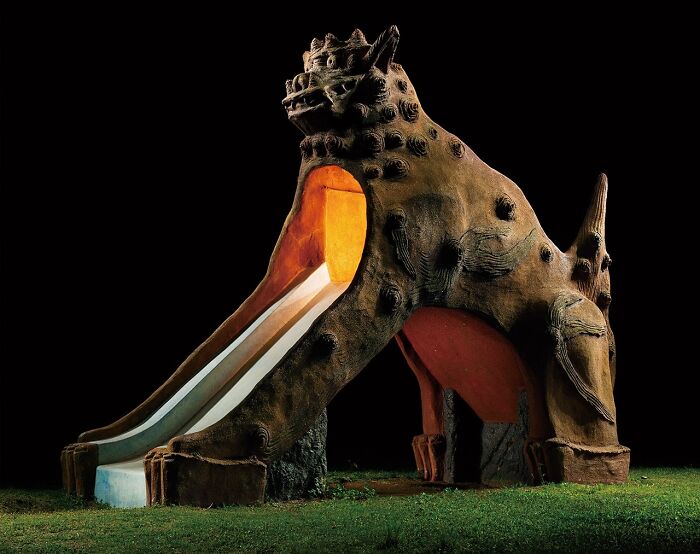 Surreal Japanese playground at night featuring a mythical creature slide by Fujio Kito.