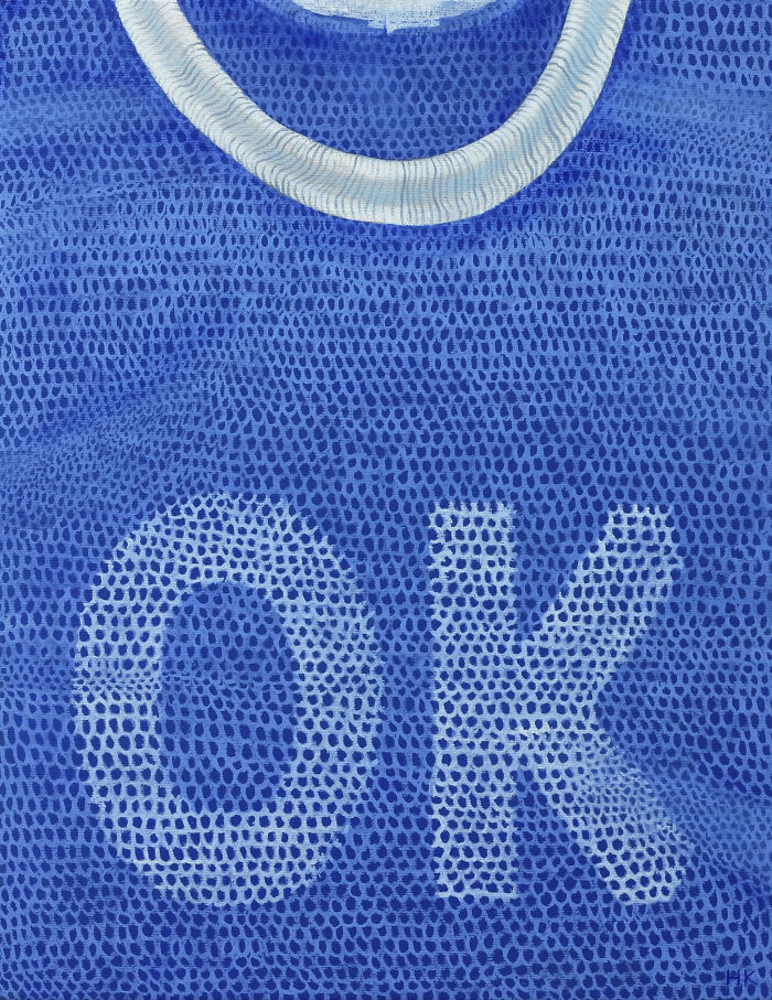 A striking portrait of identity featuring a blue slogan t-shirt with the word OK visible through the mesh fabric.