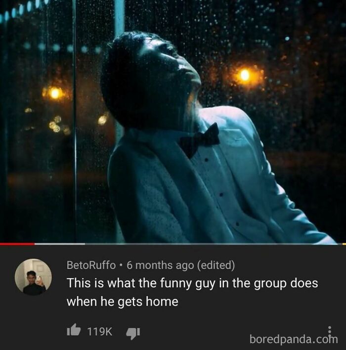 A man in a suit looking up in the rain, a YouTube video still with a relatable and poignant comment.