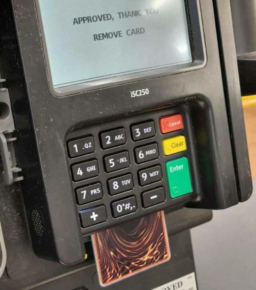 A chaotic image of a Yu-Gi-Oh card inserted into a credit card machine, displaying 'APPROVED, THANK YOU'.