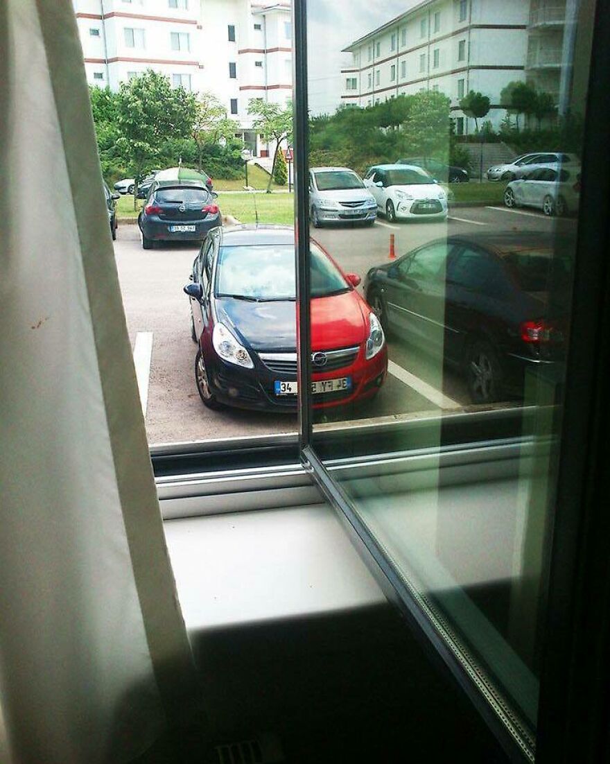 A chaotic image of a black and red car perfectly split by a window frame, creating a disturbing visual.