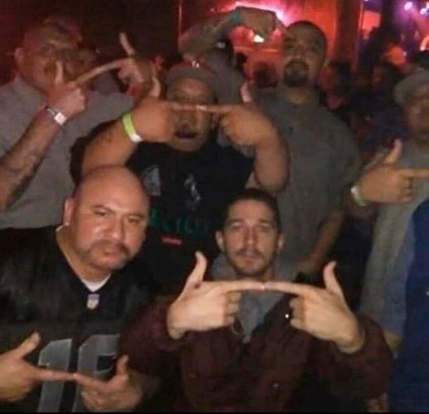 A chaotic and disturbing pic of a group of men, including Shia LaBeouf, making finger gun gestures.