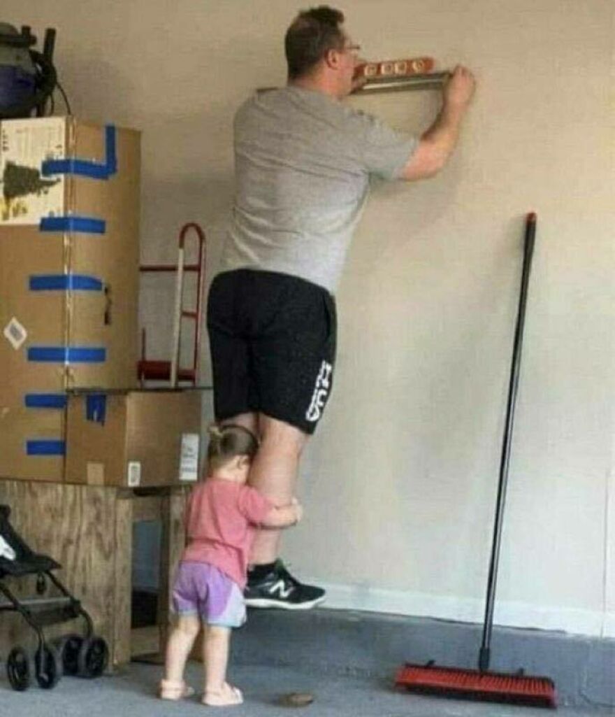 A father standing on a small child to reach higher on a wall, a chaotic and disturbing sight.