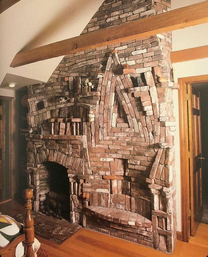 A questionable home improvement project featuring a bizarrely constructed brick fireplace with various patterns and protruding bricks.