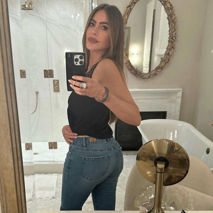 Sofia Vergara in a bathroom selfie, showing a subtle celebrity Photoshop fail in the mirror's reflection.
