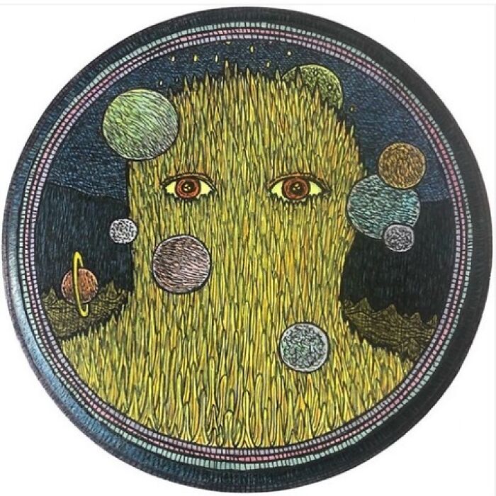 Theo Ellsworth circular artwork featuring a yellow face surrounded by planets