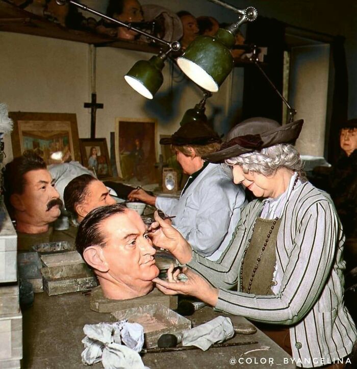 Women meticulously working on wax figures in a workshop, captured in a stunning historical colorized photo.
