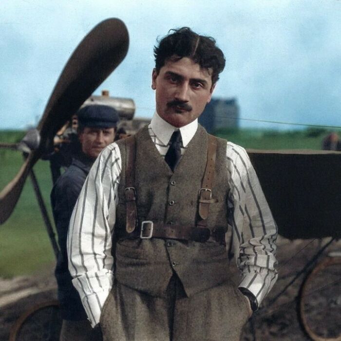 A historical colorized photo of an aviator standing in front of an airplane, making the past come to life.