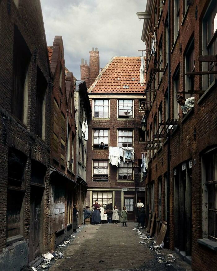 Historical colorized photos: A narrow alleyway with children and adults, laundry hanging from windows.