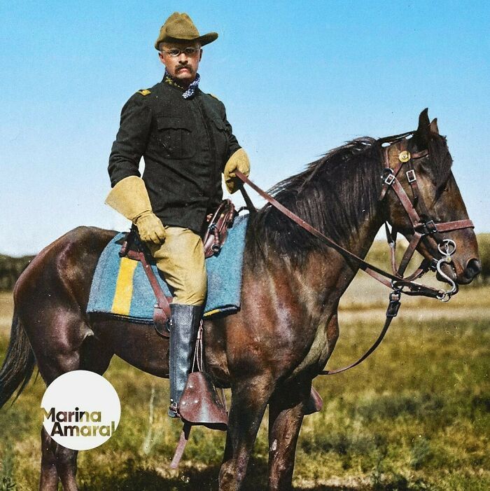 Historical colorized photo of Theodore Roosevelt on horseback in a field.