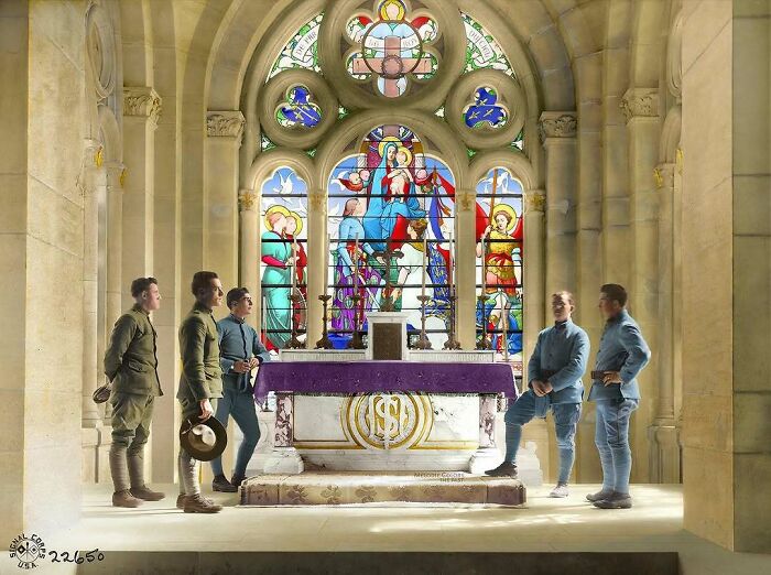A historical colorized photo of soldiers standing in a church with stained glass windows, making past days come to life.