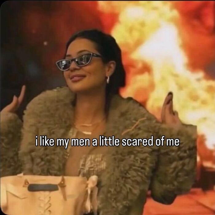 A meme of a woman in sunglasses and a fur coat, smirking, with a fiery background, captioned 'i like my men a little scared of me'.