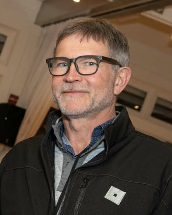 A public figure with a beard and glasses, wearing a black jacket, destroying his legacy.