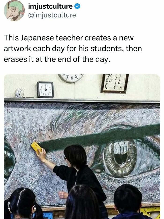 A Japanese teacher erasing a large artwork of an eye on a blackboard, creating daily artwork for students.