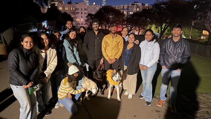 A group of pet owners and their dogs at night, showcasing the dog owner community. A group of pet owners and their dogs at night, showcasing the dog owner community.
