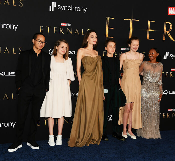 Angelina Jolie standing with her children, including daughter Zahara, at a movie premiere event.