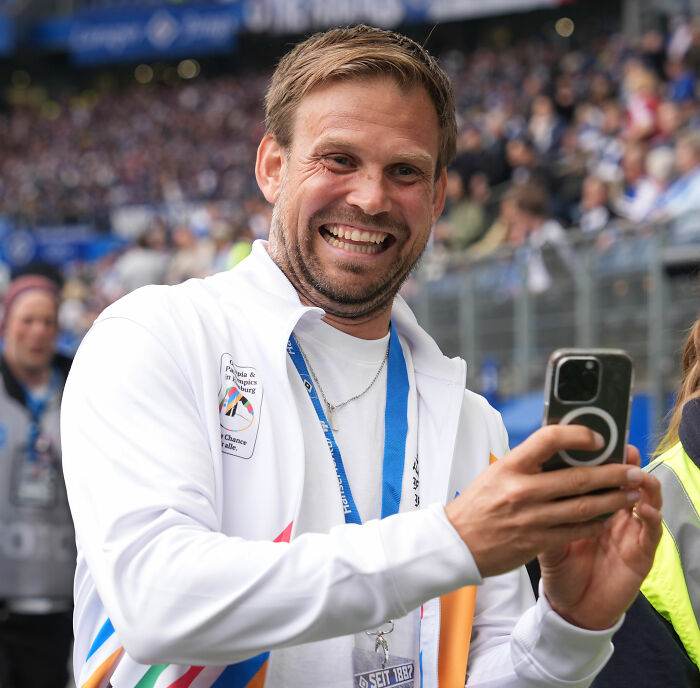 HYROX CEO smiling and taking a picture at a race event, facing backlash for athlete incident.