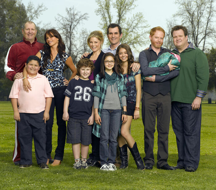 Modern Family cast members pose for a reunion pic, with many recognizable faces and a few absent stars.