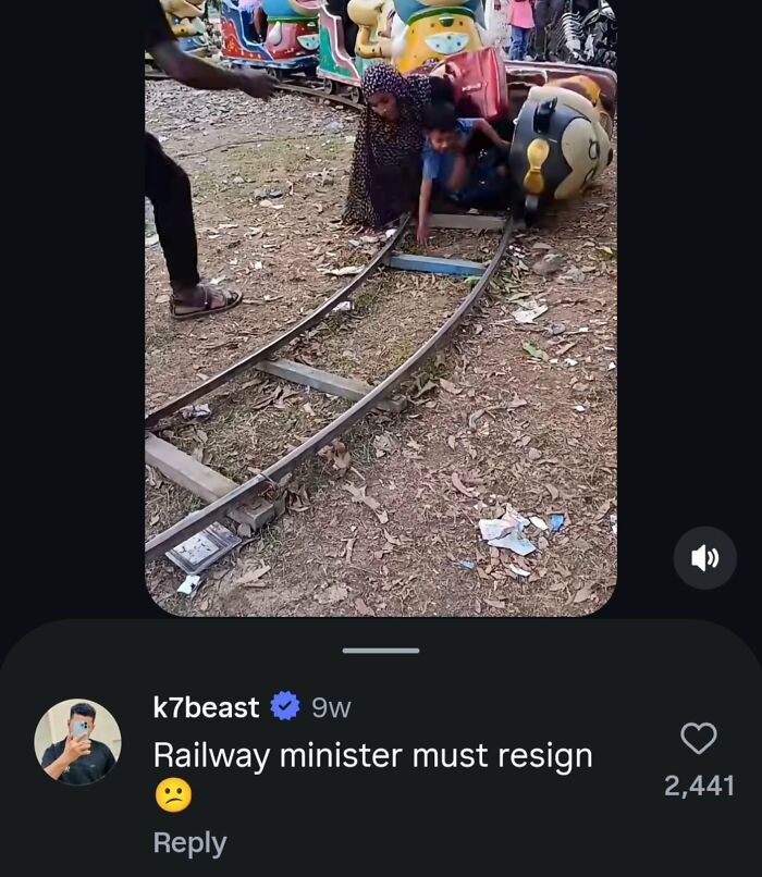 A man pushes a small, broken train with children on it, a perfect reply about railway issues.