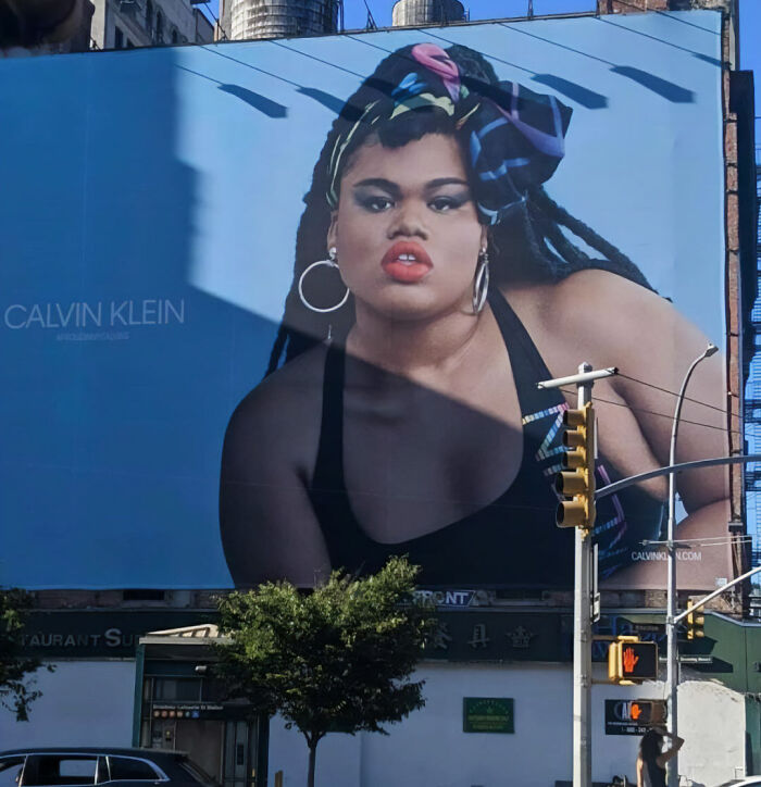 A Calvin Klein ad billboard featuring a plus-sized model in a tank top, part of a viral comparison to past ads. A Calvin Klein ad billboard featuring a plus-sized model in a tank top, part of a viral comparison to past ads.
