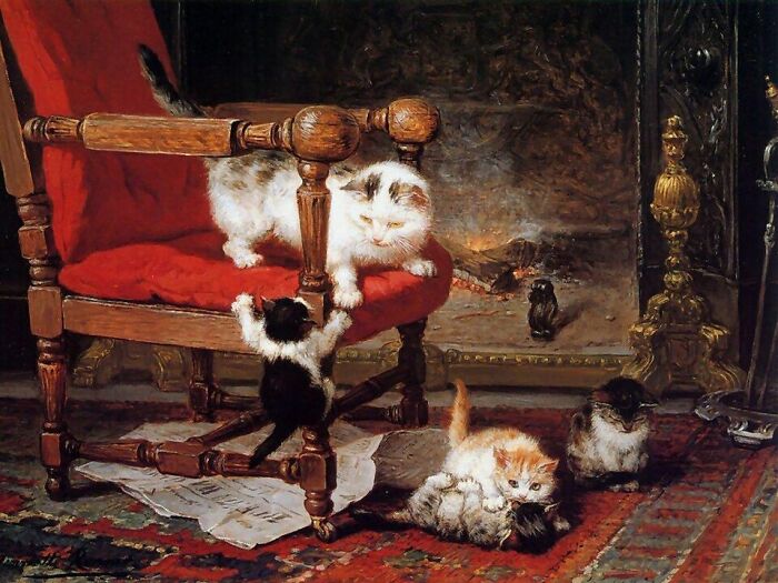 19th Century cat paintings: Playful kittens near a fireplace, one climbing a red chair, others on the floor.