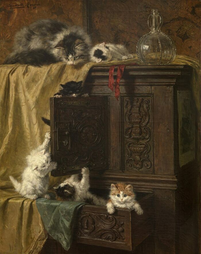 A charming 19th-century cat painting showing several cats and kittens exploring an ornate wooden cabinet.