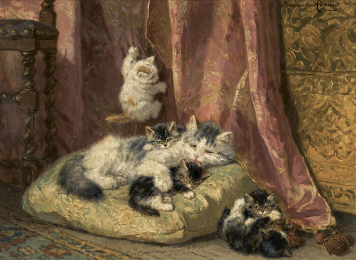 A 19th-century cat painting showing a mother cat and her kittens resting on a cushion, with another kitten playing. A tender cat painting scene.