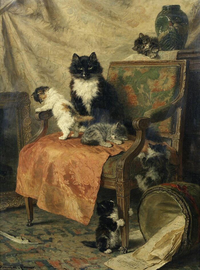 19th Century cat paintings: A black and white cat with her kittens in a room with an ornate chair and vase.