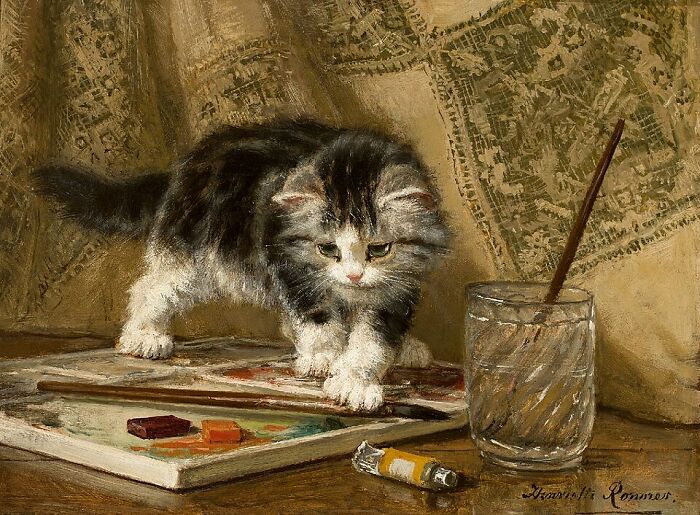 Artist's cat paintings: A fluffy kitten curiously steps on a paint palette next to a glass of water in this 19th-century artwork.
