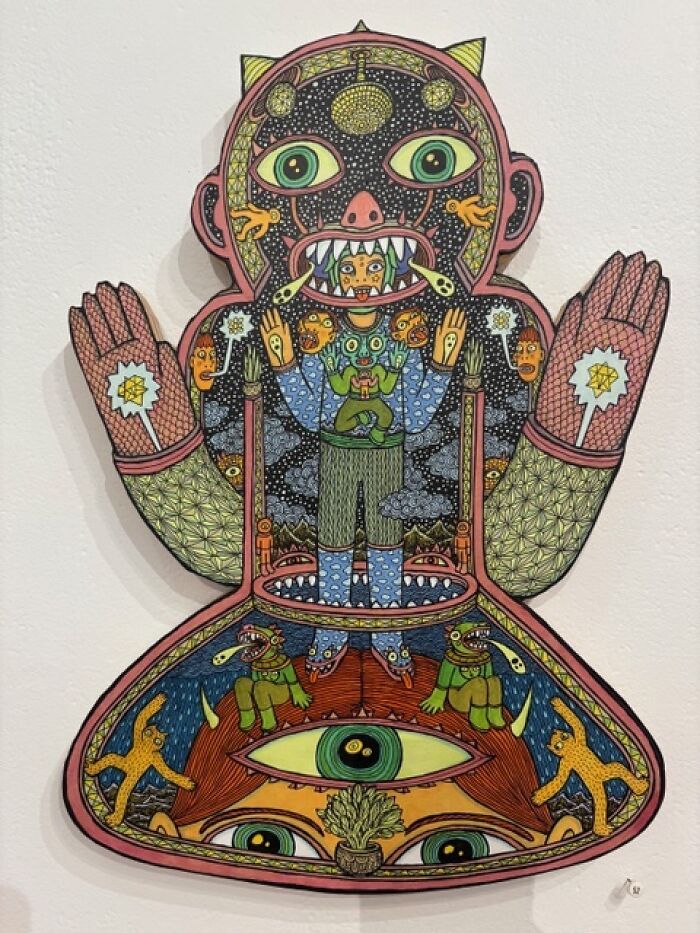 Intricate Theo Ellsworth figure with eyes, creatures, and cosmic patterns in a bold cutout design