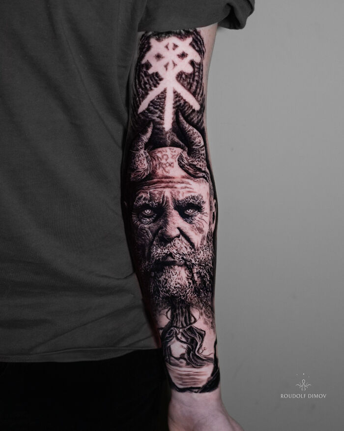 An ancient mythology inspired tattoo featuring a horned figure, a striking design from Sacred Gold Studio.