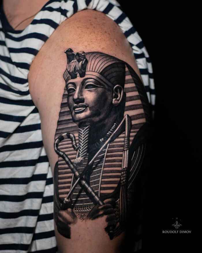 A detailed ancient mythology tattoo of an Egyptian pharaoh on an arm from Sacred Gold Studio.