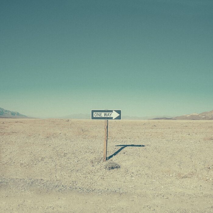 A One Way sign in the vast, dusty American West, symbolizing a bygone era of exploration.