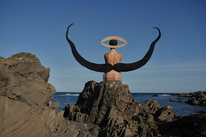 Surreal art expedition photo of figure with large black horns sitting on rocky shore