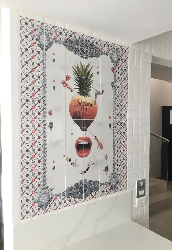 Wall tile works with pineapple hot air balloon and surreal hands in a modern kitchen setting