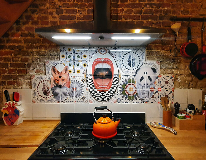 Colorful tile works backsplash with fox, open mouth, and panda above stove