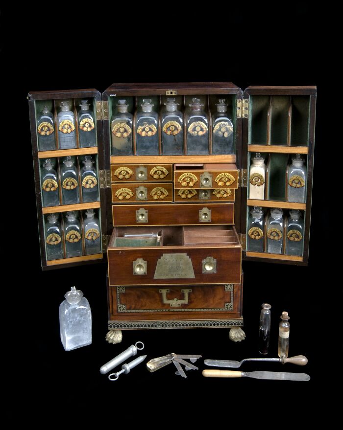 A detailed antique medicine chest filled with glass vials from medical history