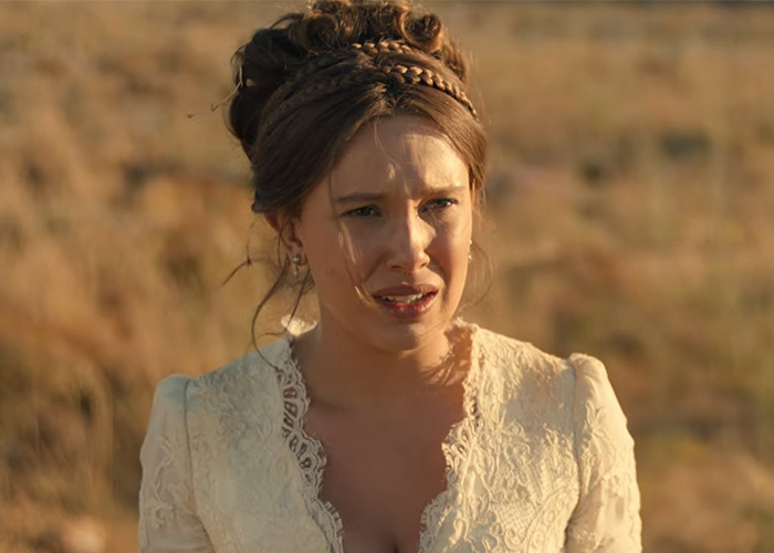 Millie Bobby Brown looking distressed in a film scene, illustrating Hollywood's plastic surgery obsession.