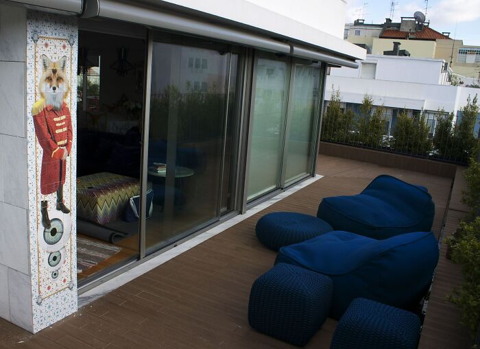 Outdoor tile works installation with fox figure beside large glass doors