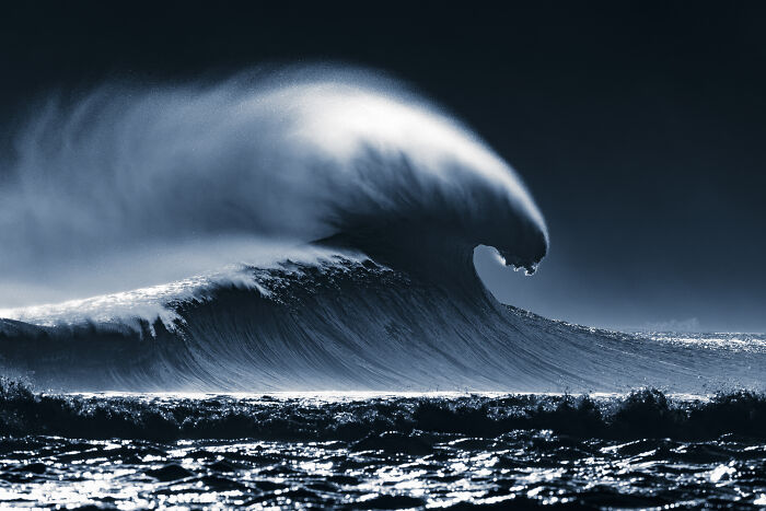 A powerful, cresting ocean wave illuminated from behind, a stunning image from the Ocean Photographer Of The Year Awards.