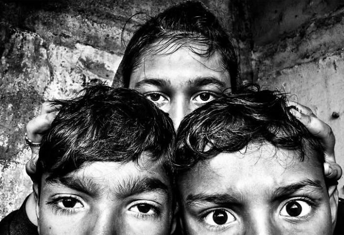 Murat Harmanlikli's street photo capturing the curiosity and intensity of childhood with three children peering up.