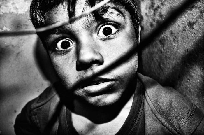Murat Harmanlikli's street photo showing the intensity of childhood, with a boy's wide-eyed, curious expression.