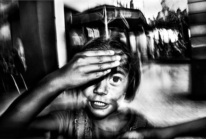 Murat Harmanlikli's street photos illustrate the joy and curiosity of childhood through a child covering her eyes.