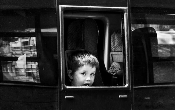 A black and white street photo by Murat Harmanlikli capturing the intensity and curiosity of childhood.