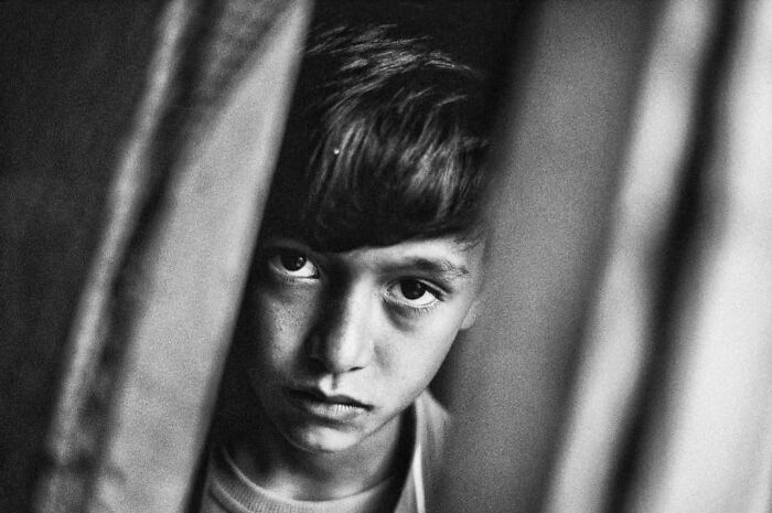 A black and white street photo by Murat Harmanlikli capturing the intensity and curiosity of childhood.