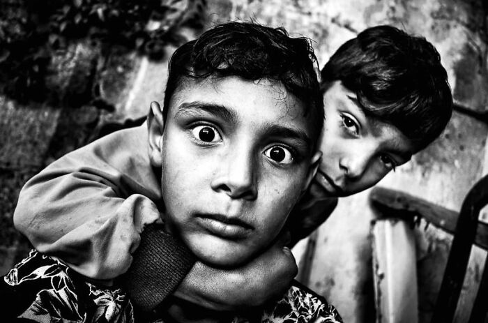 Murat Harmanlikli's street photo captures two boys, one with wide-eyed intensity, showing childhood curiosity and emotion.