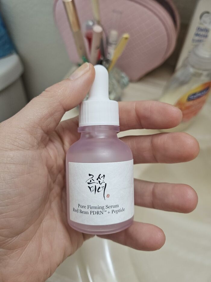 A hand holding a bottle of Beauty of Joseon Pore Firming Serum, a skincare favorite from Prime Big Deal Days