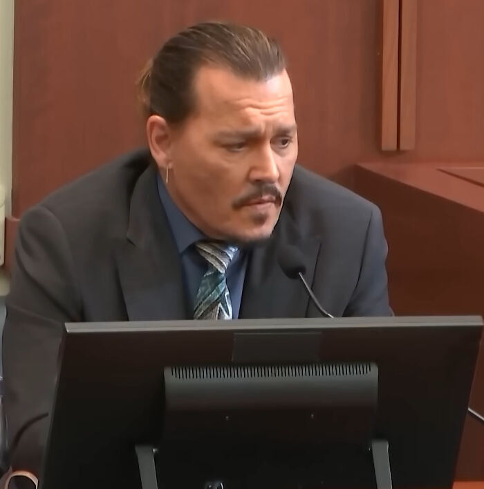 Johnny Depp in a suit, looking pensive, sharing his brutal hot take on celebrities.