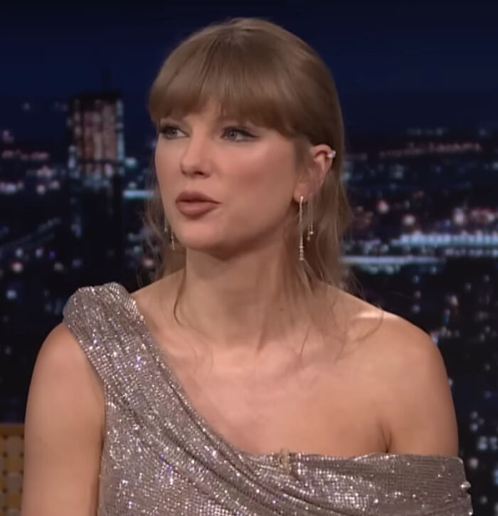 Taylor Swift in a sparkly one-shoulder dress, offering a brutal hot take on celebrities.