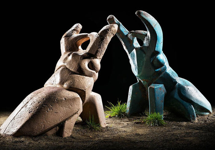 Two large beetle-shaped sculptures glow in the darkness of a Japanese playground at night by Fujio Kito.